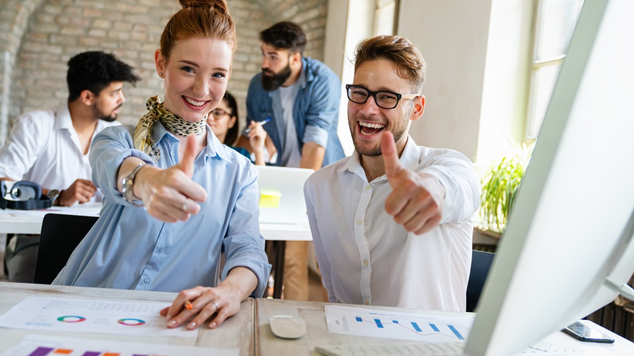 formación bonificada. Dos personas sonriendo sacando el pulgar hacia arriba
